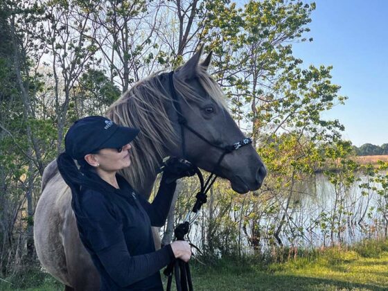 Simone mit einem Mustang an der Wasserstelle.